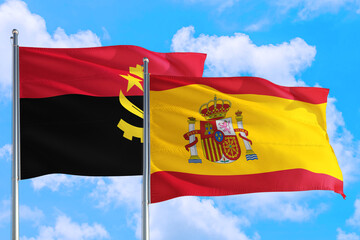Fototapeta premium Spain and Angola national flag waving in the windy deep blue sky. Diplomacy and international relations concept.