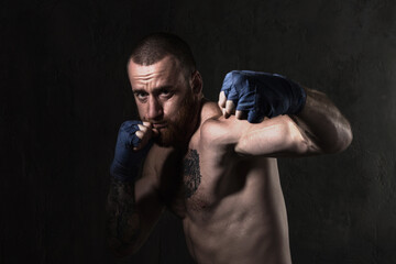 Studio session with one muscular man in low-key light conditions