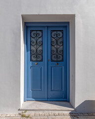 simple double blue painted wooden door and white washed wall, Athens Greece