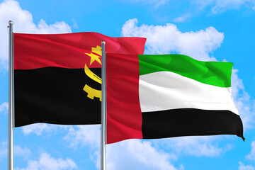 United Arab Emirates and Angola national flag waving in the windy deep blue sky. Diplomacy and international relations concept.