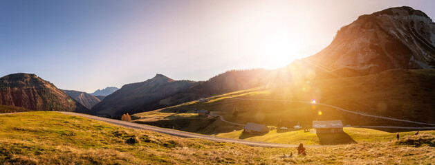 Alpine landscape scenery in fall. Sundown, warm colors and alpine huts.