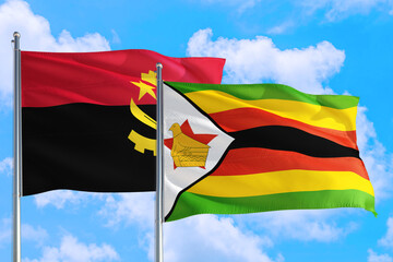 Zimbabwe and Angola national flag waving in the windy deep blue sky. Diplomacy and international relations concept.