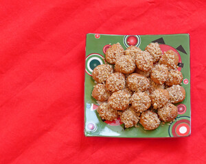 melomacarona, traditional Greek Christmas gourmet cookies with honey syrup and nuts, served on red fabric background