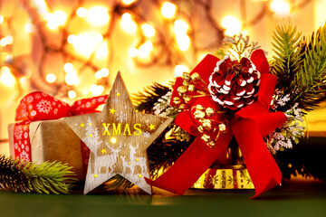 Vintage Christmas decoration with wooden star, red bow with pine cone and Lights On Wooden Table
