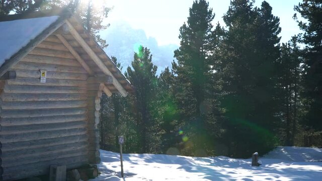 A house with a snowman and the mountains in the background