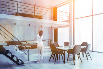 Woman in white living room corner with stairs