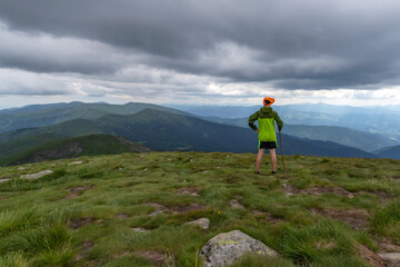 A young man looks at the beautiful mountains. Success. Tourism.