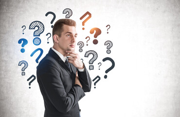 Young businessman and question marks