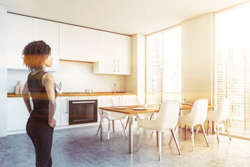 African woman in white kitchen with table