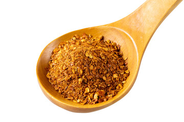 Thai red chili seasoning lies in a lacquered wooden spoon. Isolated on white background. Close-up.