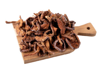 Dried honey mushrooms lie on a small cutting board. Isolated on white background. Close-up.