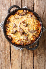 Albanian lamb and rice Tave kosi casserole baked with a mixture of yoghurt and eggs close-up in a pan on the table. vertical top view from above - obrazy, fototapety, plakaty