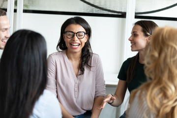 Warm workplace relations. Happy diverse multiethnic corporate staff chatting communicating on team briefing in office, laughing on good joke, having funny moment in work talk conversation discussion