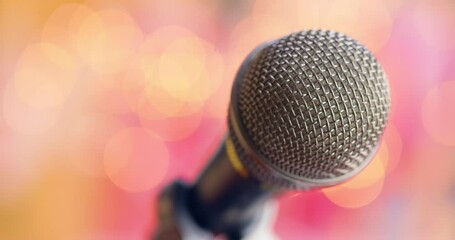 Microphone on stage against a blurry light ,blurry background.