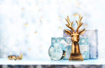 Christmas winter greeting card with golden deer, boxes gifts, and glass magic ball. Festive background with garland lights, and space for text