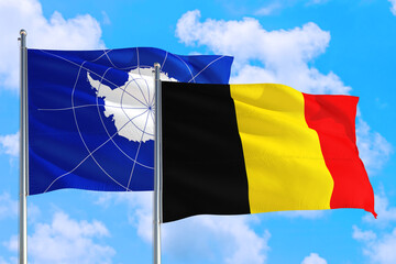 Belgium and Antarctica national flag waving in the windy deep blue sky. Diplomacy and international relations concept.