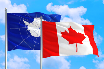 Canada and Antarctica national flag waving in the windy deep blue sky. Diplomacy and international relations concept.