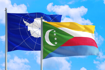 Comoros and Antarctica national flag waving in the windy deep blue sky. Diplomacy and international relations concept.