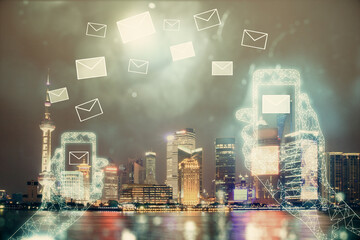 Double exposure of envelop hologram flying from gadget and city view background. Concept e-mail.