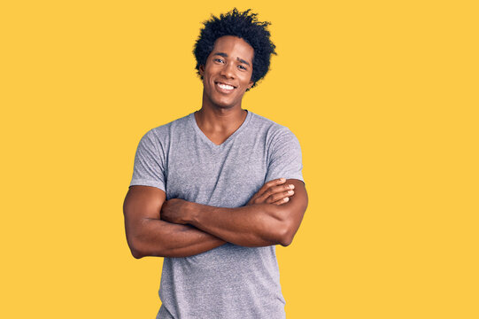Handsome african american man with afro hair wearing casual clothes happy face smiling with crossed arms looking at the camera. positive person.