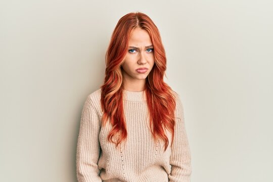 Young beautiful redhead woman wearing casual winter sweater skeptic and nervous, frowning upset because of problem. negative person.
