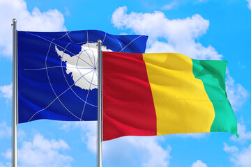 Guinea Bissau and Antarctica national flag waving in the windy deep blue sky. Diplomacy and international relations concept.