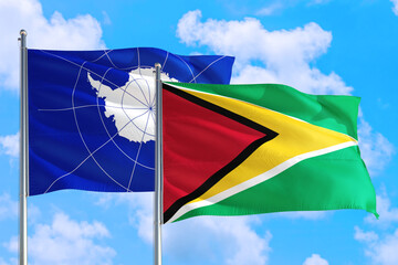 Guyana and Antarctica national flag waving in the windy deep blue sky. Diplomacy and international relations concept.