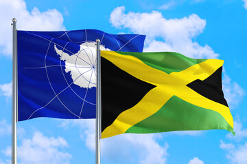 Jamaica and Antarctica national flag waving in the windy deep blue sky. Diplomacy and international relations concept.