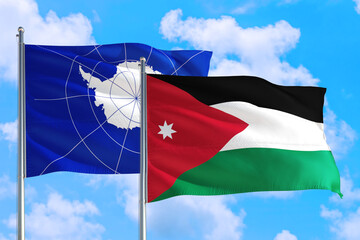 Jordan and Antarctica national flag waving in the windy deep blue sky. Diplomacy and international relations concept.
