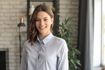 Cheerful woman student professional standing at home in office looking at camera.