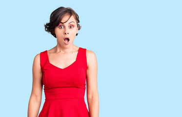 Beautiful young woman with short hair wearing casual style with sleeveless shirt afraid and shocked with surprise and amazed expression, fear and excited face.