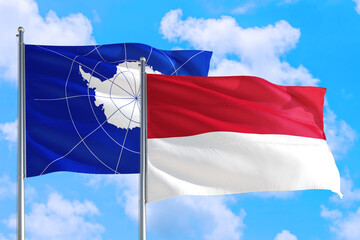 Monaco and Antarctica national flag waving in the windy deep blue sky. Diplomacy and international relations concept.