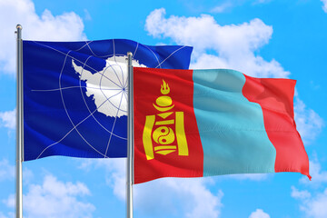 Mongolia and Antarctica national flag waving in the windy deep blue sky. Diplomacy and international relations concept.