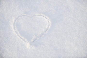 One heart in the snow. A heart is drawn on the snow close-up. The shape of heart on the snow. Winter background..