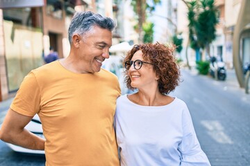 Middle age couple smiling happy standing at street of city.