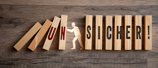 Pieces of wood with the german words for Sure and Unsure - sicher und unsicher on wooden background