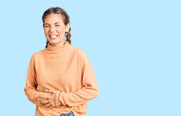Beautiful caucasian woman with blonde hair wearing casual winter sweater with hand on stomach...