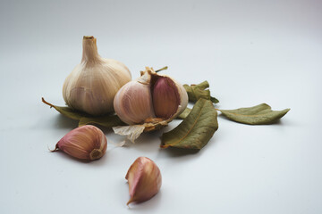 Detalle de diente de ajo seco con hojas verdes de laurel alrededor
