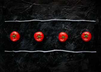 four tomatoes on a dark stone background linear kitchen view