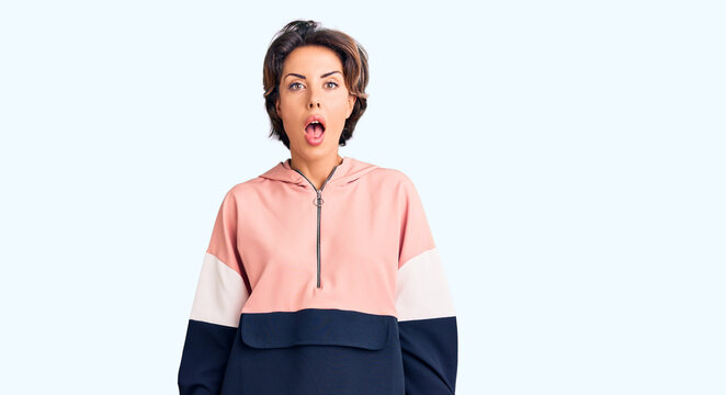 Young beautiful woman wearing sportswear afraid and shocked with surprise and amazed expression, fear and excited face.