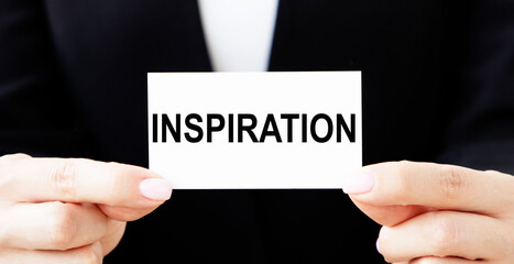 The businessman holds a business card with the text INSPIRATION.