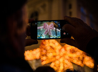 person taking a picture of a christmas decoration