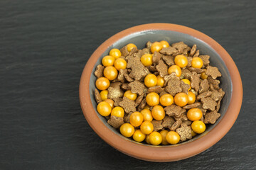 background of sugar sprinkles in orange and brown with stars and balls