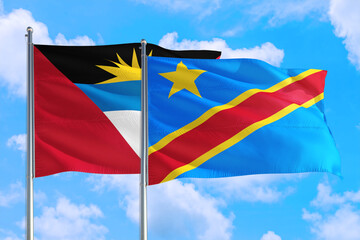 Congo and Antigua and Barbuda national flag waving in the windy deep blue sky. Diplomacy and international relations concept.