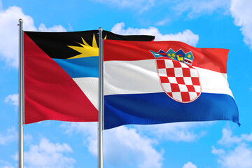 Croatia and Antigua and Barbuda national flag waving in the windy deep blue sky. Diplomacy and international relations concept.