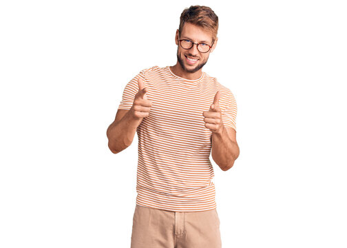Young caucasian man wearing casual clothes and glasses pointing fingers to camera with happy and funny face. good energy and vibes.