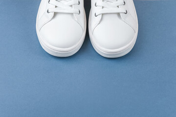 White sports shoes, sneakers with shoelaces on blue background. Sport lifestyle concept Top view Flat lay Copy space