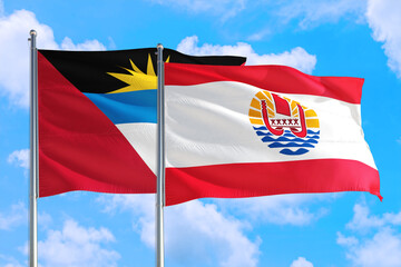 Fototapeta na wymiar French Polynesia and Antigua and Barbuda national flag waving in the windy deep blue sky. Diplomacy and international relations concept.