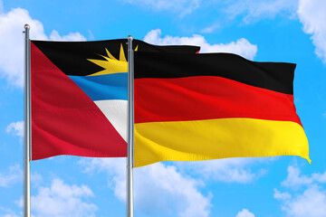 Germany and Antigua and Barbuda national flag waving in the windy deep blue sky. Diplomacy and international relations concept.
