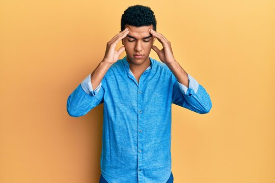 Young arab man wearing casual clothes with hand on head for pain in head because stress. suffering migraine.